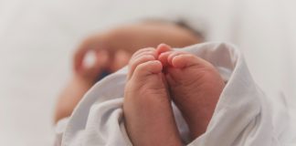 baby covered with white blanket