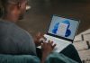 man in gray long sleeve shirt using Windows 11 computer