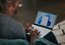 man in gray long sleeve shirt using Windows 11 computer