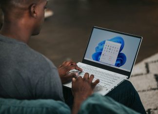 man in gray long sleeve shirt using Windows 11 computer