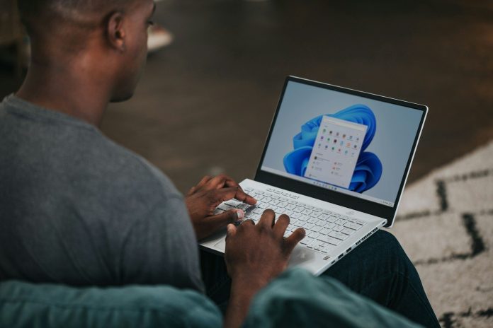 Photo by Windows man in gray long sleeve shirt using Windows 11 computer