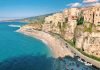 an aerial view of a beach with a cliff in the background