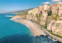 an aerial view of a beach with a cliff in the background