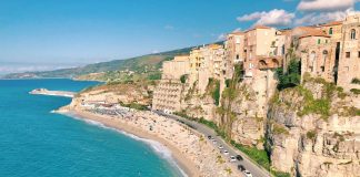 an aerial view of a beach with a cliff in the background