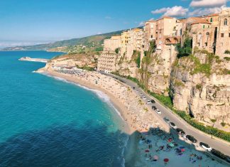 an aerial view of a beach with a cliff in the background