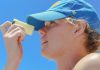a woman wearing a blue hat looking through a magnifying glass