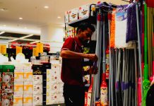 Man arranging cleaning supplies in a store