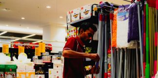 Man arranging cleaning supplies in a store