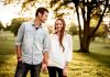 man holding hand of woman standing near tree