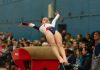 How Gymnastics Uniforms Support Performance woman in black sports bra and black leggings lying on brown concrete bench