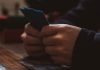 Best Android Pokies Apps Australia: Where to Find and How to Install a person sitting at a table using a cell phone
