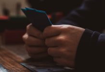 Best Android Pokies Apps Australia: Where to Find and How to Install a person sitting at a table using a cell phone