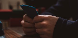 a person sitting at a table using a cell phone