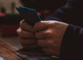a person sitting at a table using a cell phone