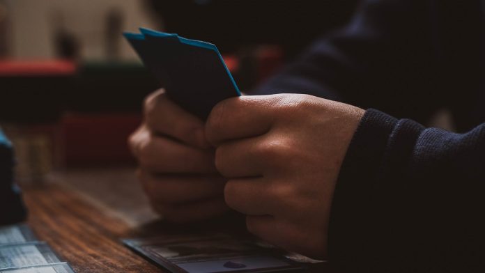 Photo by 2H Media a person sitting at a table using a cell phone