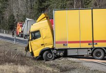 What Should You Do Immediately After a Commercial Truck Accident? A yellow semi-truck is in a roadside accident.