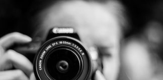 person taking photo using Canon camera in shallow focus lens
