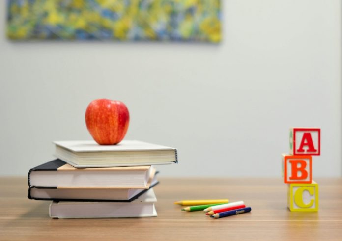red-apple-fruit-on-four-pyle-books