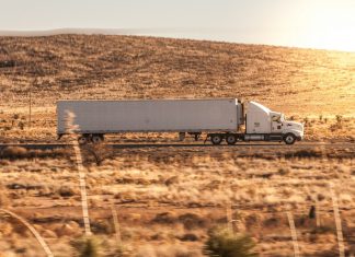 How Truck Owners Are Quietly Ruining Their Bed Liners (And How to Stop) a white semi truck driving down a rural road