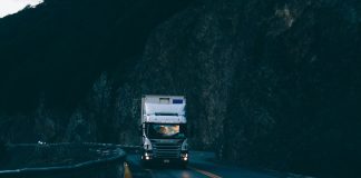 trailer truck passing on road near rail guard