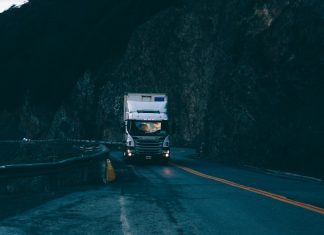 trailer truck passing on road near rail guard