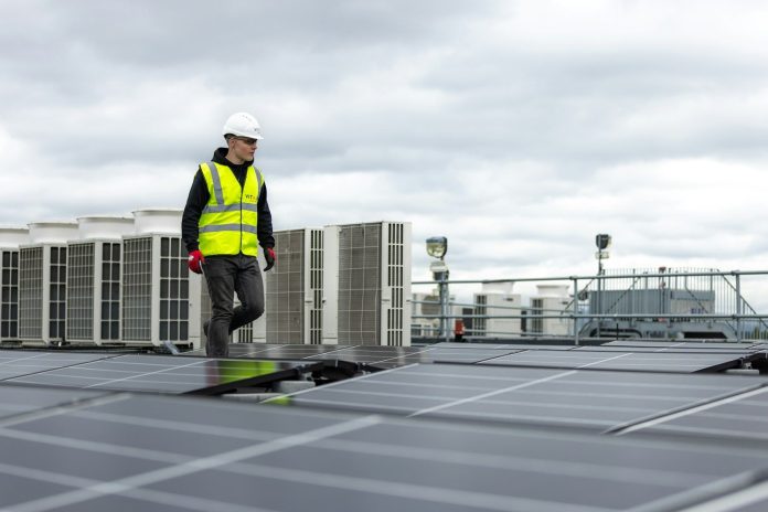 Photo by ThisisEngineering a man standing on top of a roof