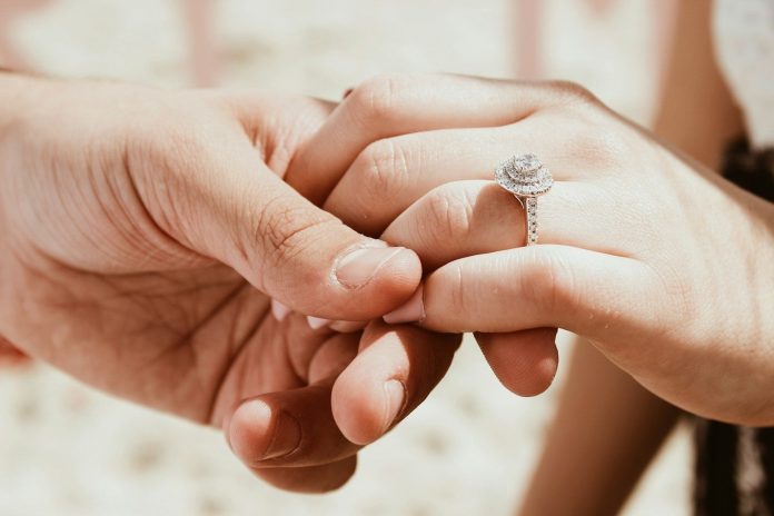 Photo by Baylee Gramling person holding another person's hand with ring