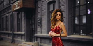 woman in red spaghetti strap dress standing on road during daytime