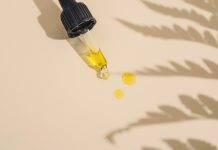 a dropper bottle filled with yellow liquid sitting on top of a table