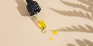 a dropper bottle filled with yellow liquid sitting on top of a table