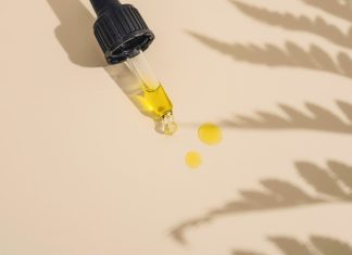 a dropper bottle filled with yellow liquid sitting on top of a table