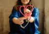 woman in scrubs holding heart shaped stethoscope