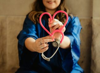 Simple Ways to Take Better Care of Your Future Health woman in scrubs holding heart shaped stethoscope