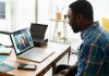 man in blue and white plaid dress shirt using macbook pro