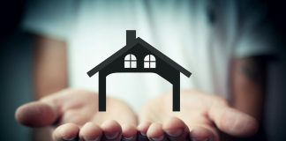 Hands holding a silhouette of a house
