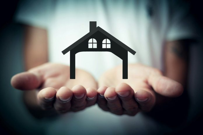 Photo by Sasun Bughdaryan Hands holding a silhouette of a house