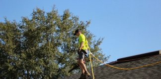 a man on a roof working with a rope