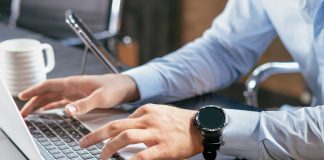 A person typing on a laptop at a desk