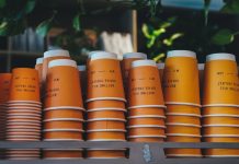 a shelf filled with orange cups sitting next to each other