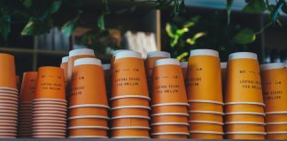 a shelf filled with orange cups sitting next to each other