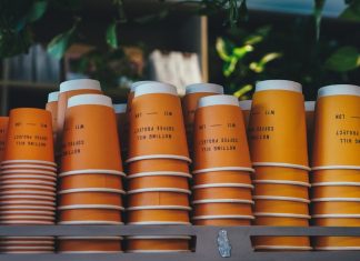 Tips for Choosing the Right Size and Style for Custom Coffee Cups a shelf filled with orange cups sitting next to each other