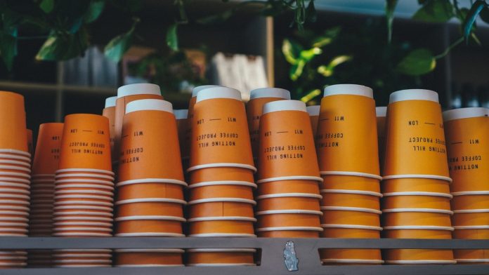 Photo by Jiamin Huang a shelf filled with orange cups sitting next to each other