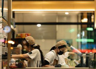 Two staff members preparing drinks in a cafe.