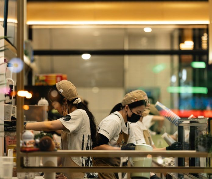 Two staff members preparing drinks in a cafe.