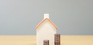 a house and stacks of coins on a table