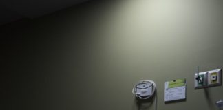 An empty hospital bed sits in a dimly lit room.