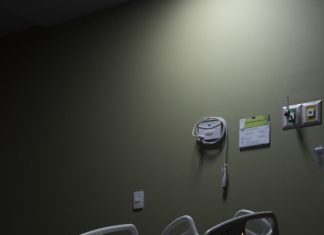 An empty hospital bed sits in a dimly lit room.