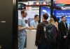 People interacting at a busy trade show booth