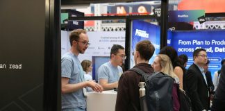 People interacting at a busy trade show booth