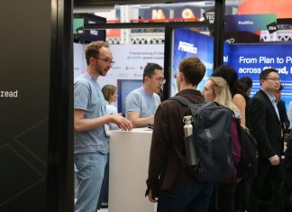 People interacting at a busy trade show booth